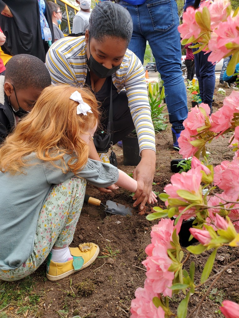 teacher planting flowers with two students