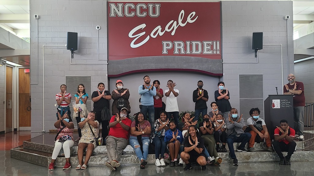 Warren County Schools students making the eagle sign with their arms, posing in front of an NCCU Eagle Pride sign